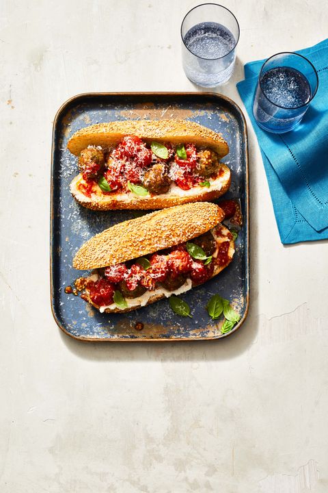 two meatball subs on a blue tray