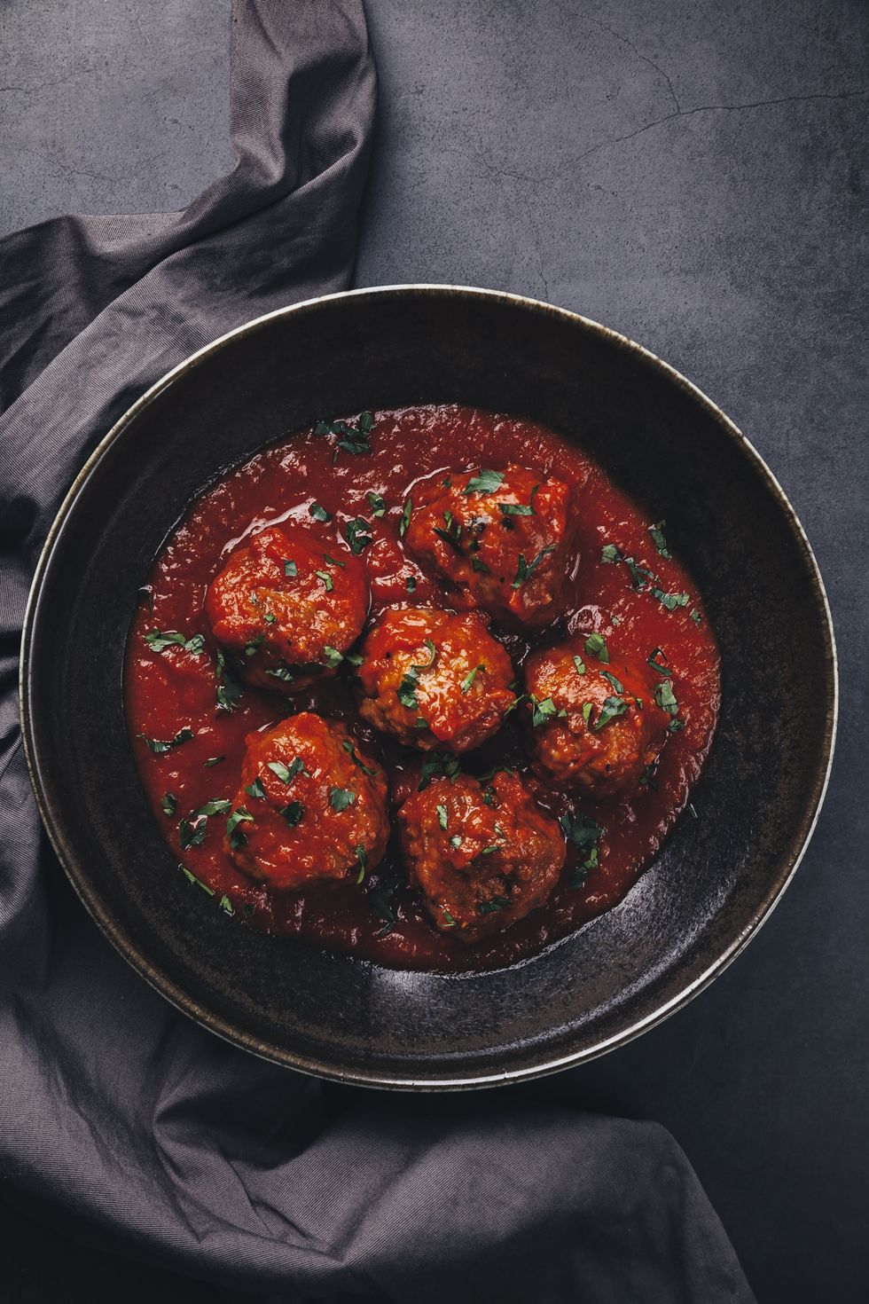 meatballs and tomato sauce on black background