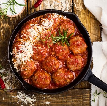 Meatballs in sour tomato sauce with grated parmesan cheese on top