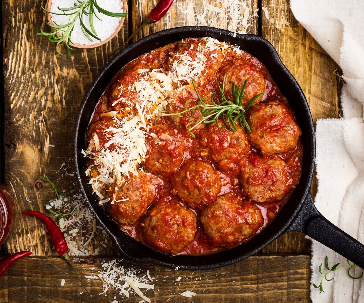Meatballs in sour tomato sauce with grated parmesan cheese on top