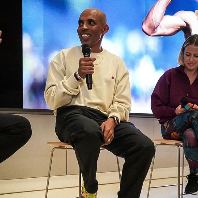 meb sitting on a chair holding a microphone
