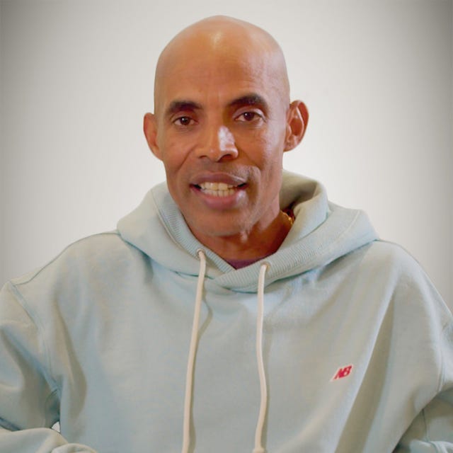 a man wearing a hoodie poses for a portrait