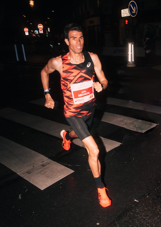 runner participating in a race during nighttime on a crosswalk