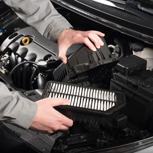 mechanic changing the air filter on a car