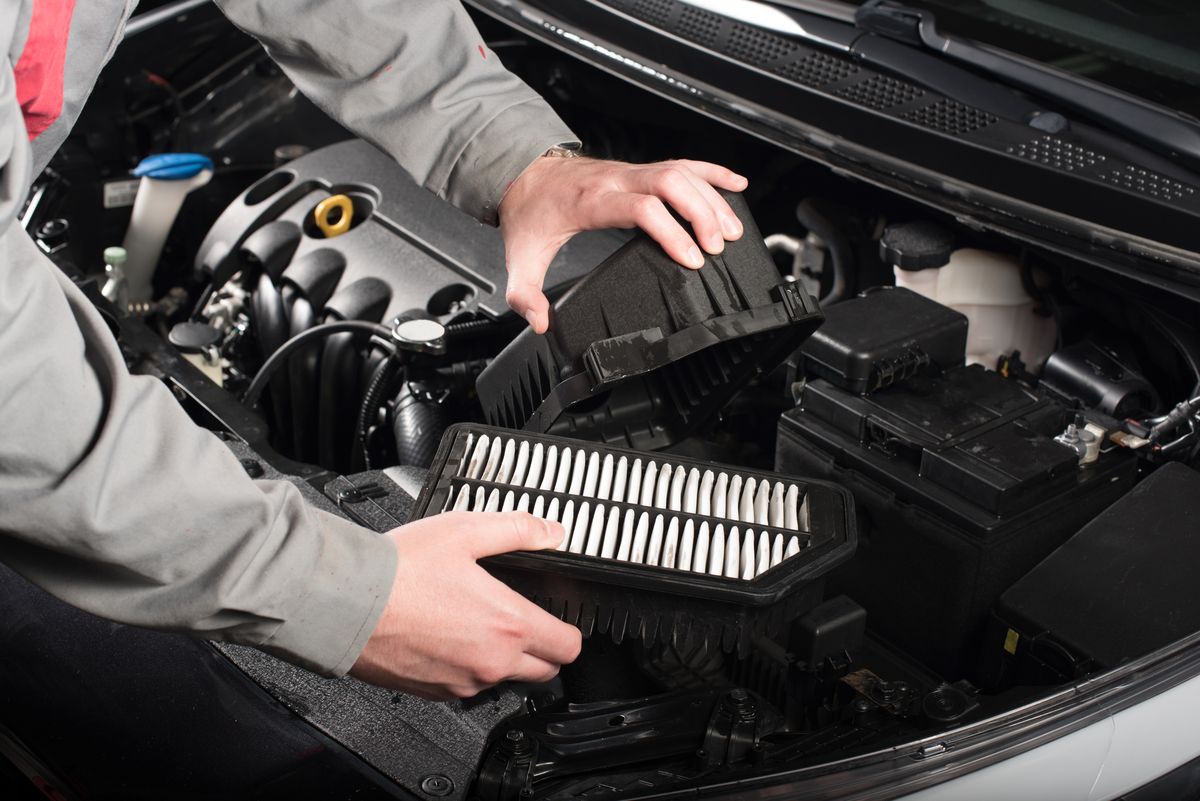 mechanic changing the air filter on a car
