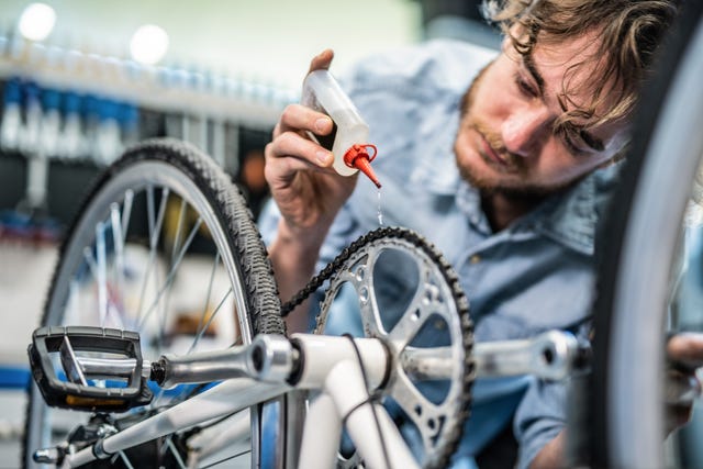 mechanic repairing bicycle breaks in workshop