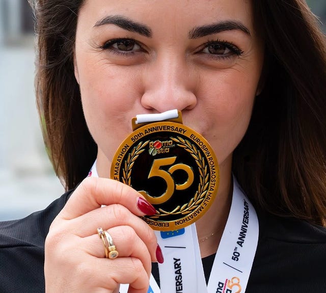 individual showcasing a medal with a ribbon