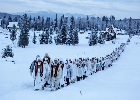 Volgers van de Christus van Siberi lopen in 2016 langs huizen in Cheremshanka op weg naar een preek die wordt gehouden op een berg in de buurt van Obitel Rassveta een Russisch dorp