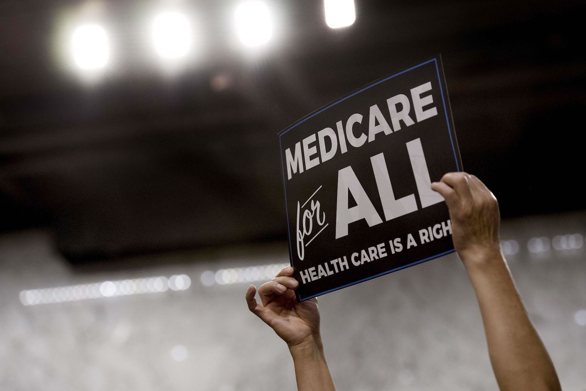 a member of the audience holds up a placard as us senator bernie sanders, independent from vermont, discusses medicare for all legislation on capitol hill in washington, dc, on september 13, 2017  the former us presidential hopeful introduced a plan for government sponsored universal health care, a notion long shunned in america that has newly gained traction among rising star democrats  afp photo  jim watson        photo credit should read jim watsonafp via getty images