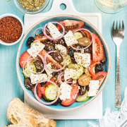 Greek salad with bread, oregano, pepper and glass of wine