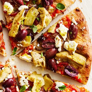 skillet pizza topped with olives, artichokes, tomatoes, feta, and onions