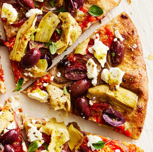 skillet pizza topped with olives, artichokes, tomatoes, feta, and onions