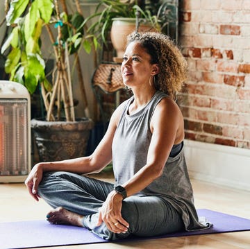 medium shot of smiling mature yoga instructor sitting in studio before class