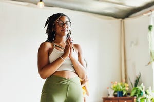 medium wide shot low angle view of woman relaxing after finishing yoga class in studio