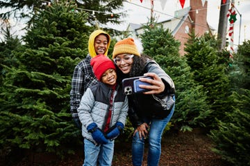 medium wide shot mother and sons taking a selfie in christmas tree lot