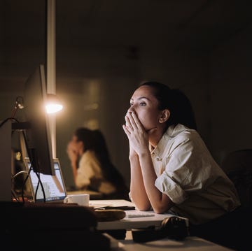 vrouw zit voor haar computer op het werk met veel stress