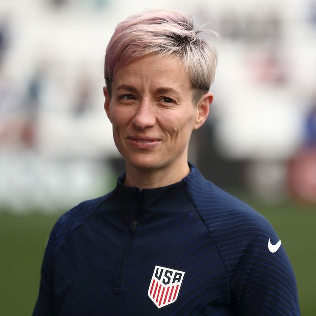 megan rapinoe looking down the field as she warms up before a soccer match
