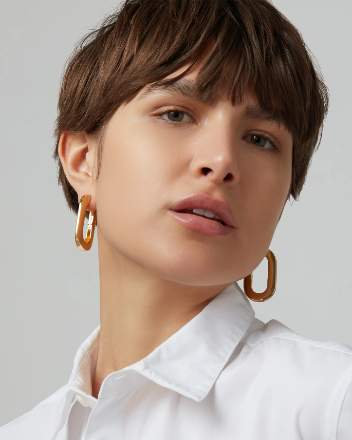 closeup of a person wearing large gold hoop earrings