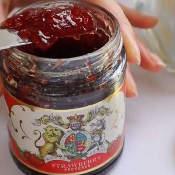 a woman holding a jar of jam
