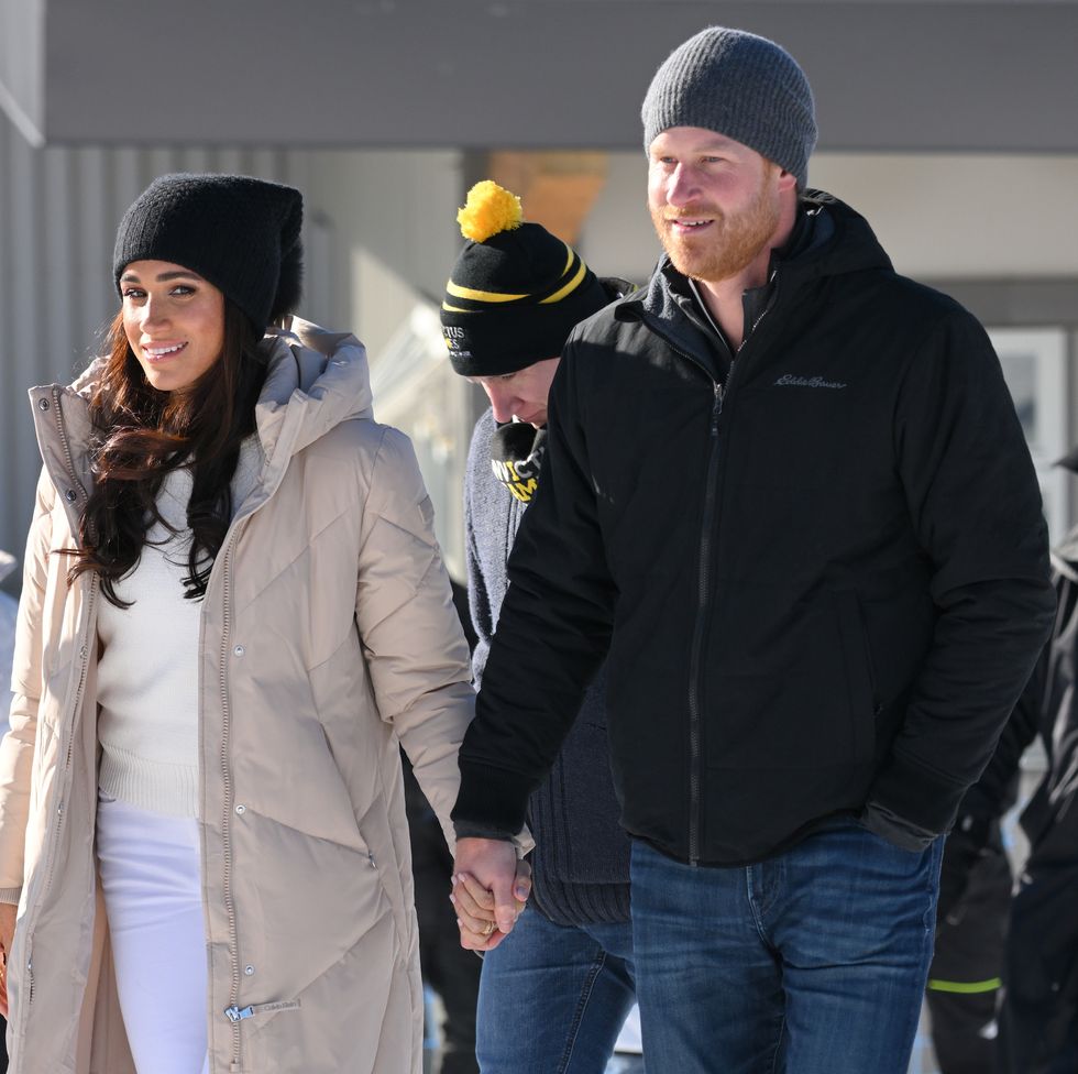 prince harry and meghan, duchess of sussex hold hands in a snow covered area