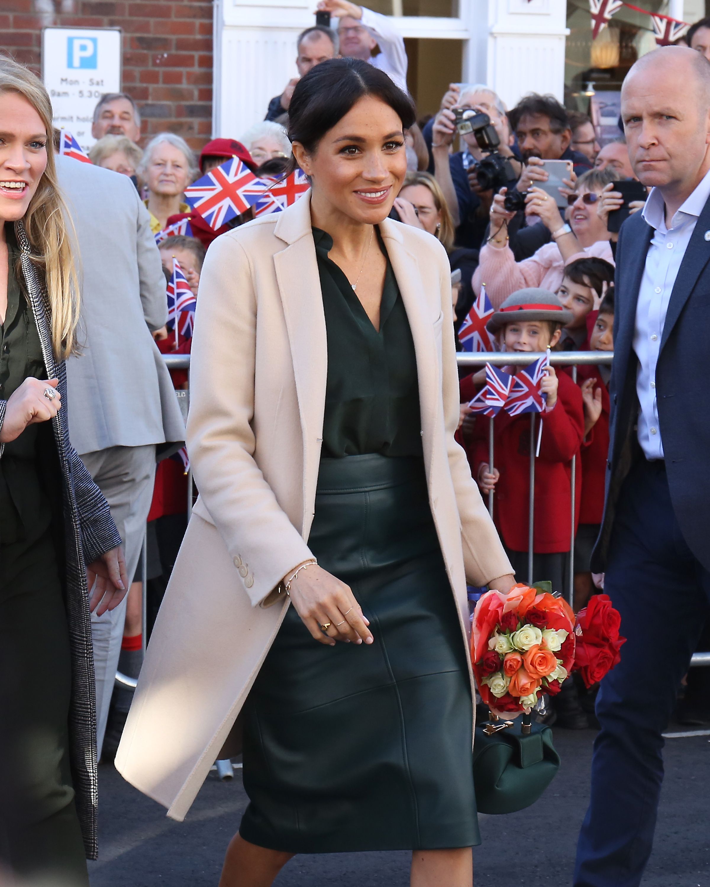 Meghan Markle con la gonna di pelle Hugo Boss e cappotto Armani