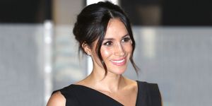 meghan markle smiles at an event with a glam updo hair style