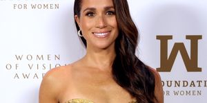 meghan markle smiles in a gold strapless dress you can see she has toned arms