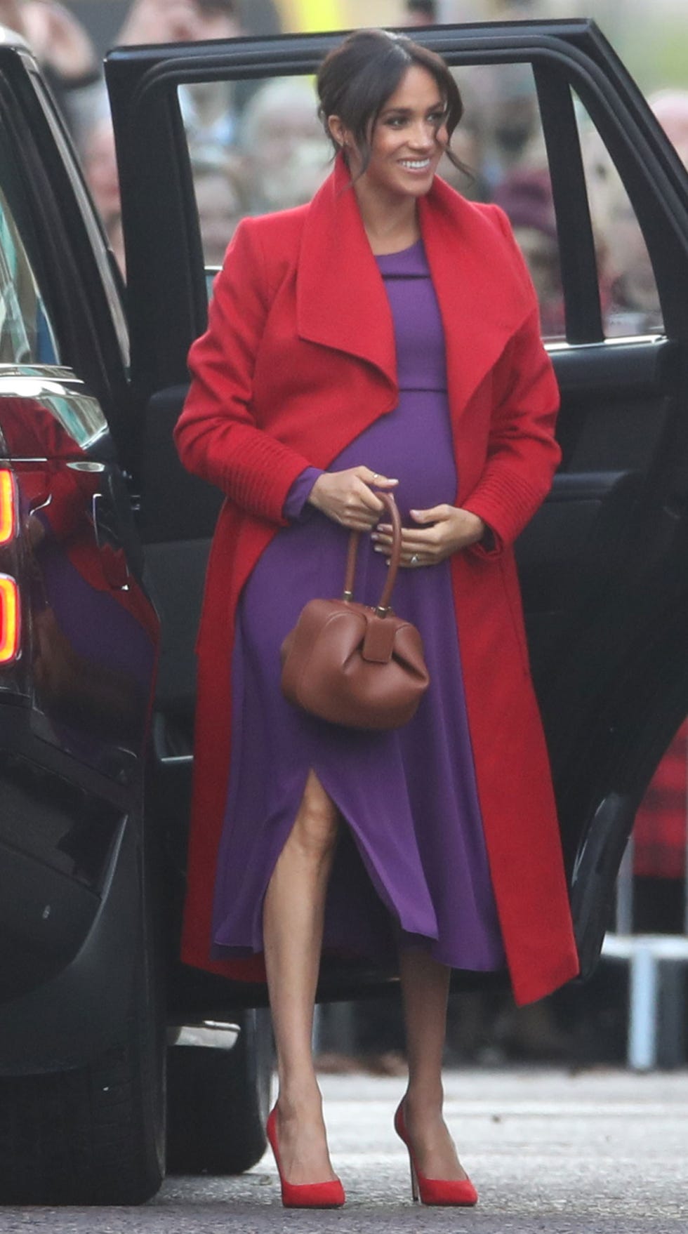 Meghan Markle, embarazada, con un look llamativo en rojo y morado en Birkenhead