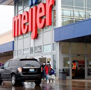 the front entrance of a meijer store with a black car parked in front