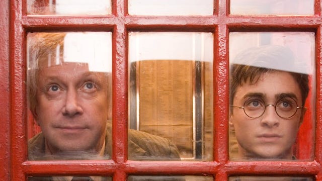 Arthur Weasley y Harry Potter, en la cabina de teléfonos de entrada al Ministerio de Magia.