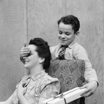 1930s 1940s boy son surprising woman mother with gift wrapped present photo by h armstrong robertsclassicstockgetty images