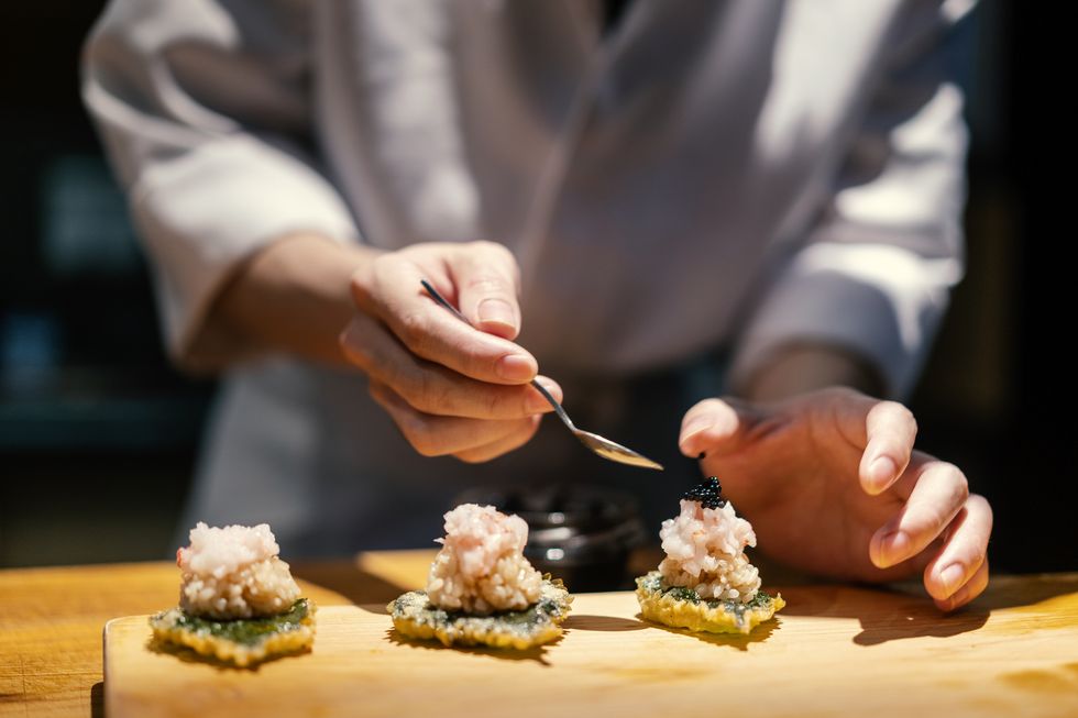 chef japonés cocinando en una barra