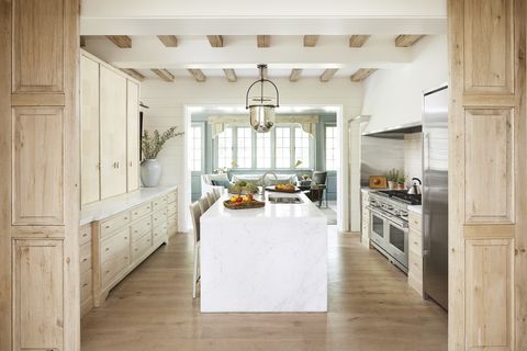white oak cabinetry and a colorado gold marble island in a centrally located kitchen