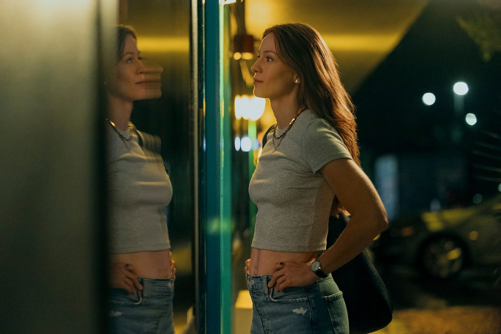 a woman standing near a reflective surface showcasing her casual outfit