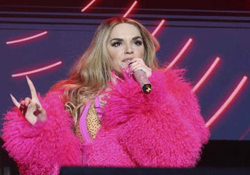 performing artist in vibrant pink outfit with microphone