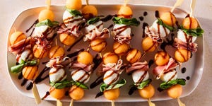 skewers with cantaloupe balls, mozzarella balls, and fresh basil leaves drizzled with balsamic glaze