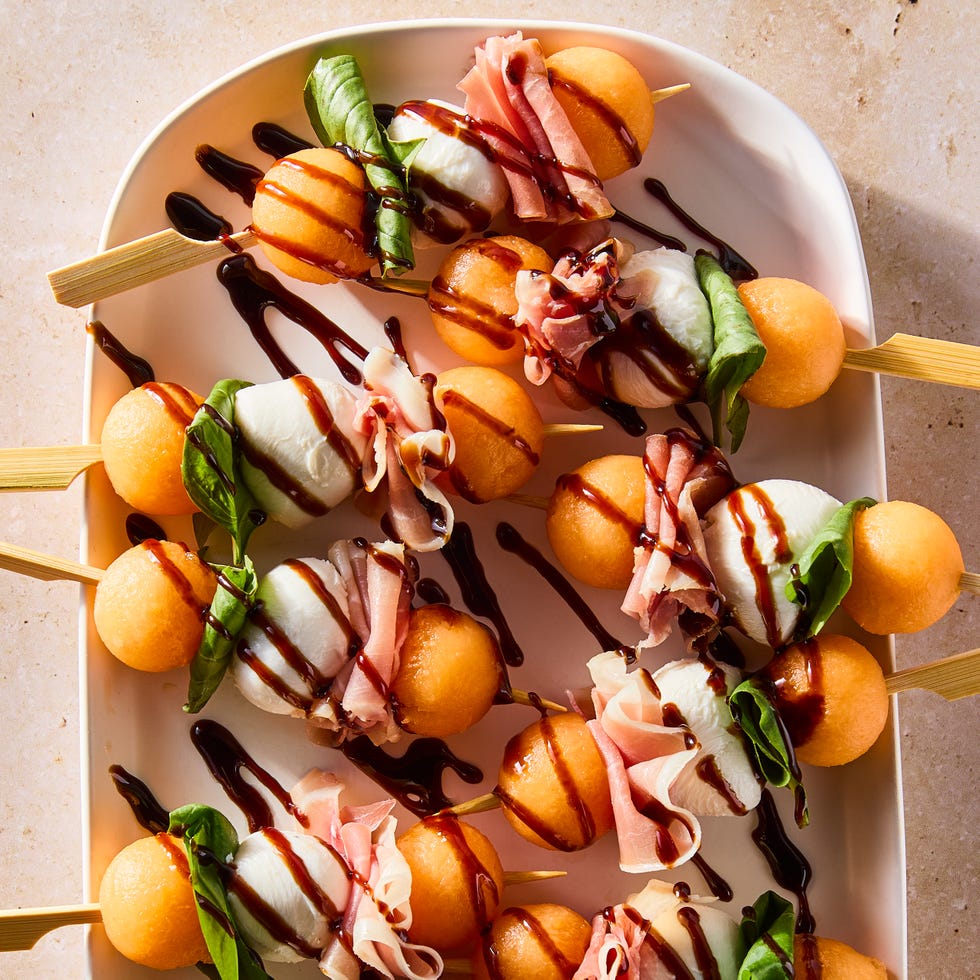 skewers with cantaloupe balls, mozzarella balls, and fresh basil leaves drizzled with balsamic glaze