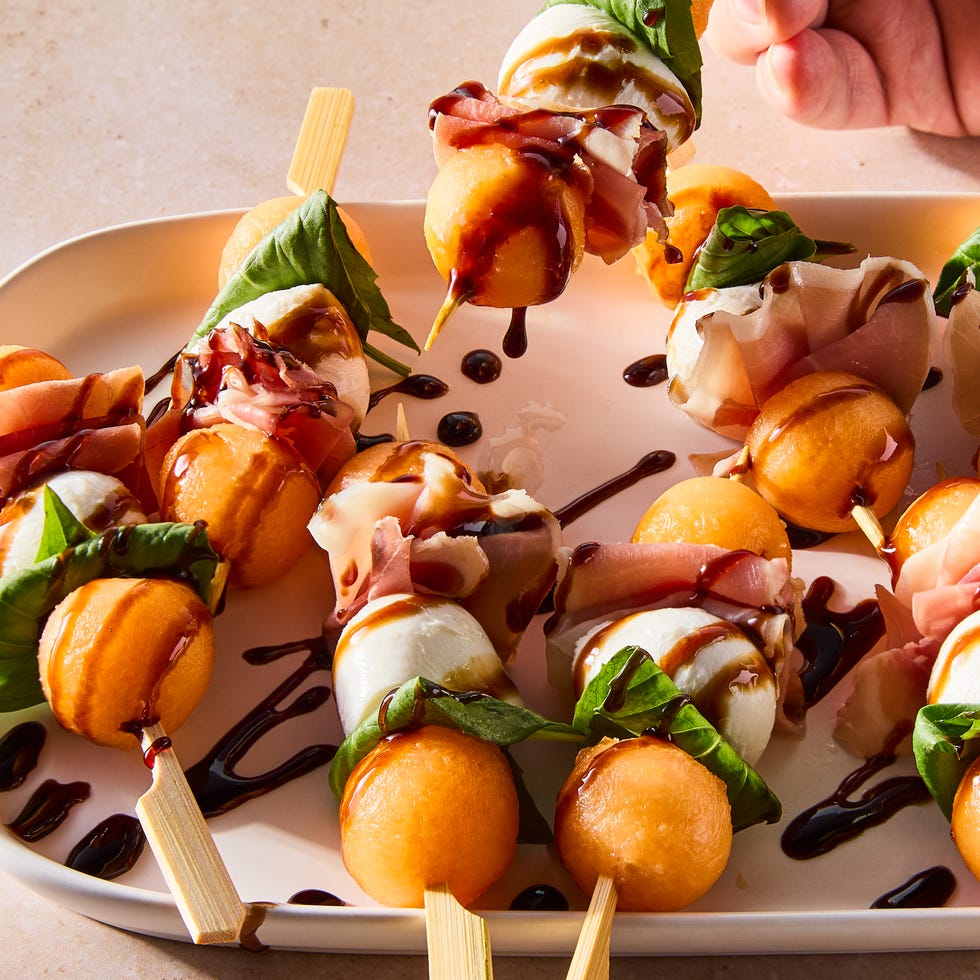 skewers with cantaloupe balls, mozzarella balls, and fresh basil leaves drizzled with balsamic glaze