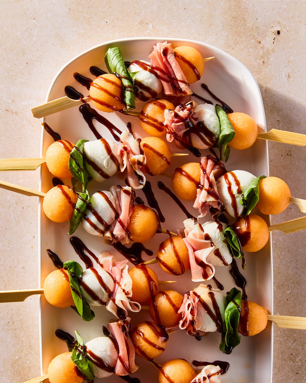 skewers with cantaloupe balls, mozzarella balls, and fresh basil leaves drizzled with balsamic glaze