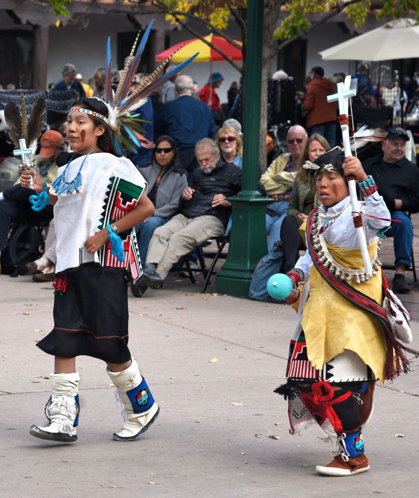 members of a dance troupe in new mexico participate in an indigenous peoples' day celebration