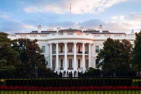 a picture of the white house in front of the lawn and gate