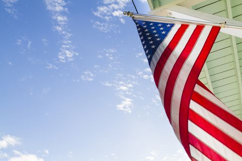 an american flag waving in the air under a clear blue sky