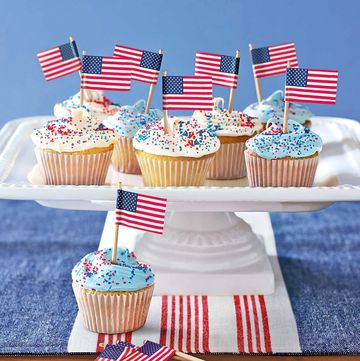 cupcakes with mini flags in them on a platter
