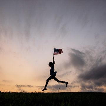 memorial day posts silhouette of kid jumping mid air holding american flag
