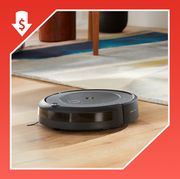 robot vacuum on wood floor and person putting apple airpods into ear