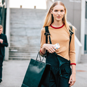 woman holding a phone and carrying a shopping bag