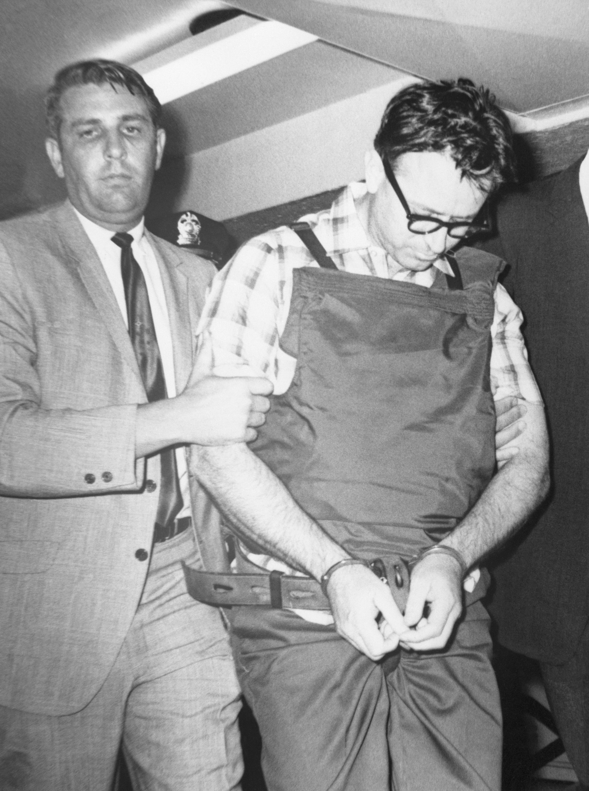 james early ray walking to his prison cell while handcuffed with his head down