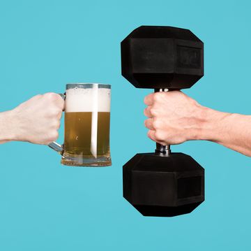 men are holding out each other a glass of beer and a large dumbbell