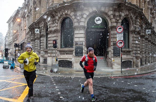 men jogging during snow fall across the capital