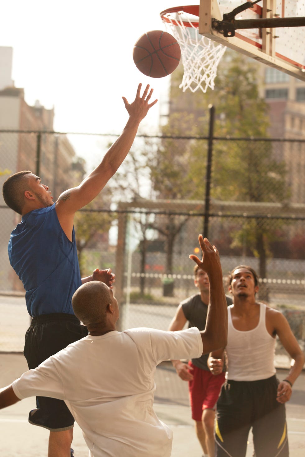 Men playing basketball on court